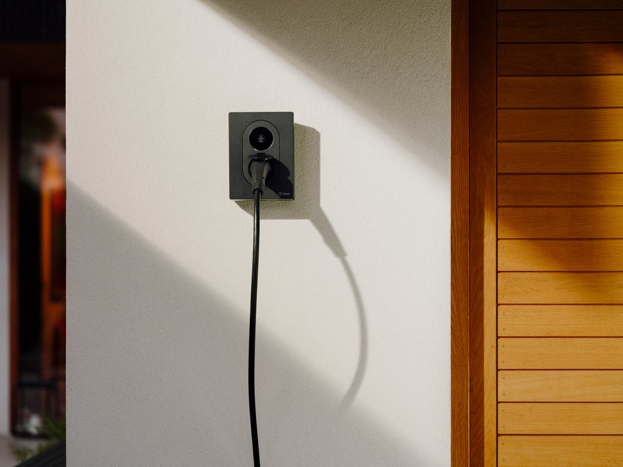 Zaptec GO 2 laadpaal geïnstalleerd aan een woning met zonlicht